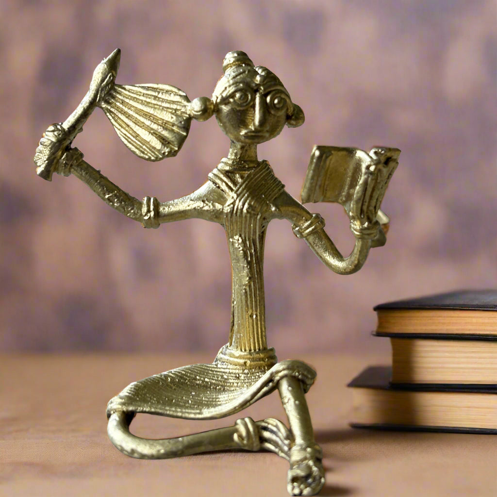 Dokra Brass Tribal Girl Reading with Hand Fan – Handcrafted Figurine from Bengal - ArtisanSoul