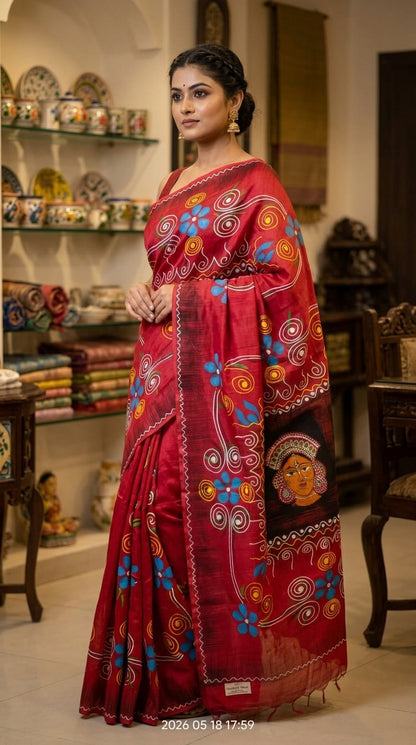 Woman wearing a handcrafted red hand-painted Batik handloom saree with folk art motifs